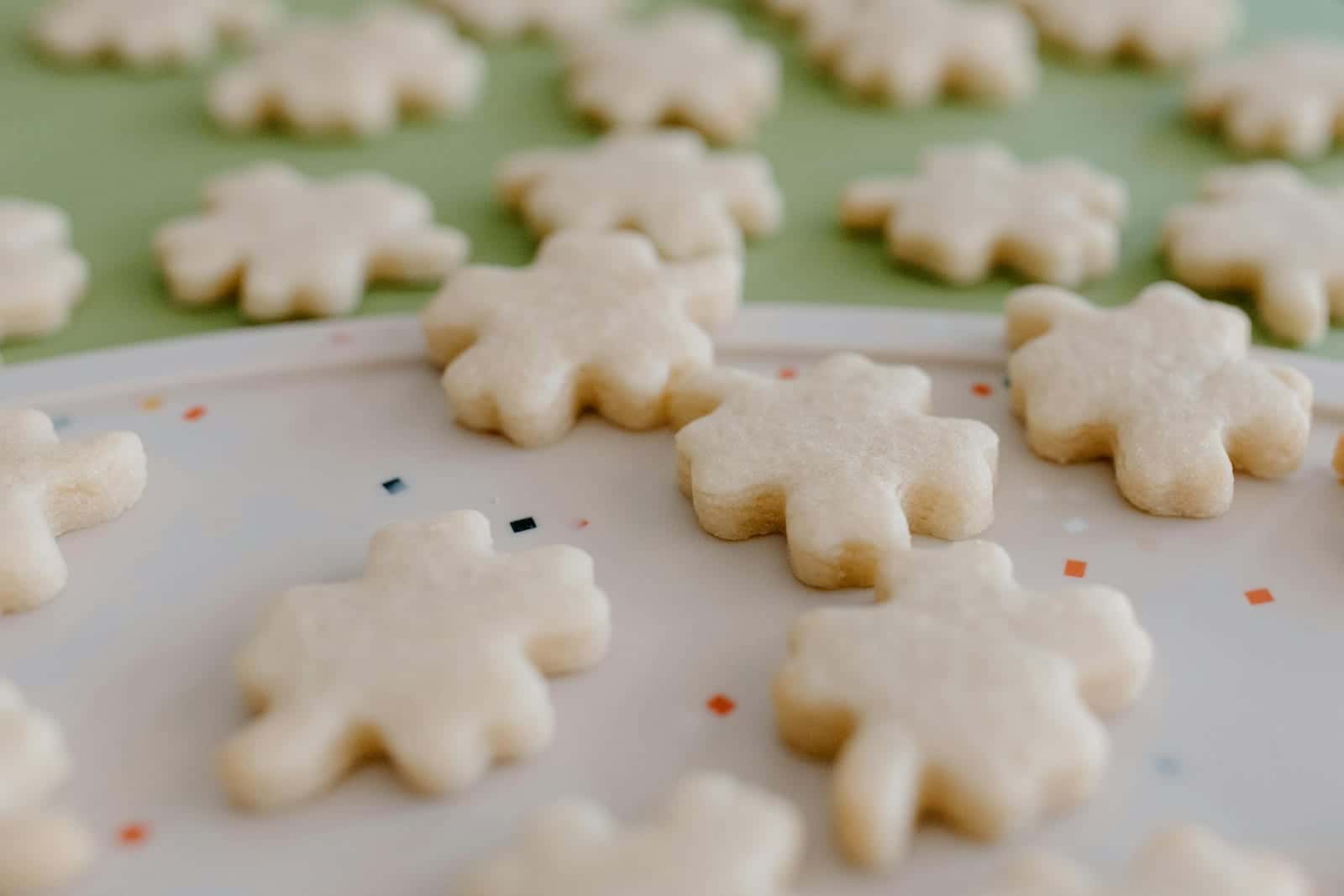 Classic sugar cookies cut into snowflake shapes and arranged on a decorative plate