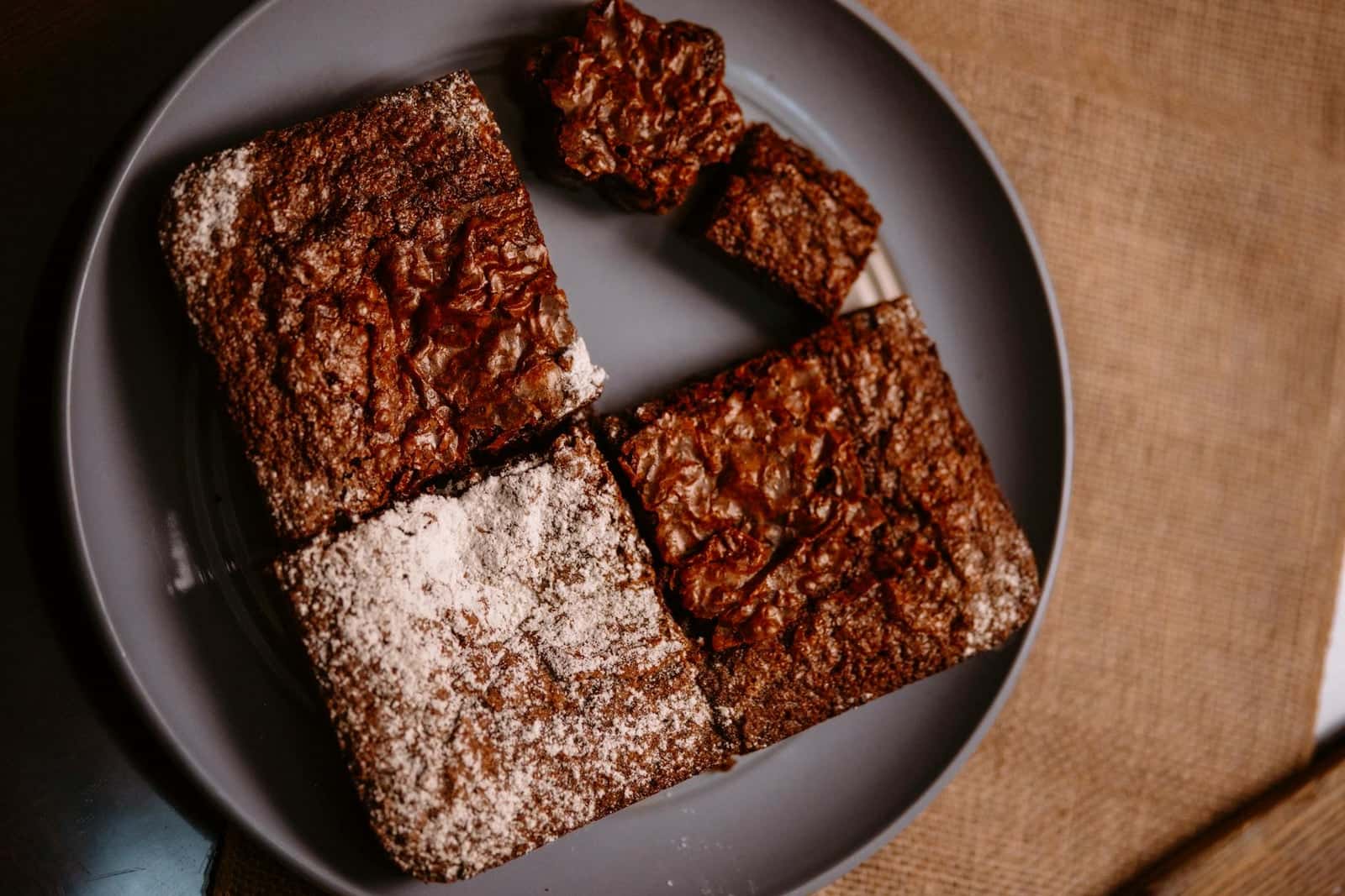 Fudgy chocolate brownies cut into squares with a shiny crackly top
