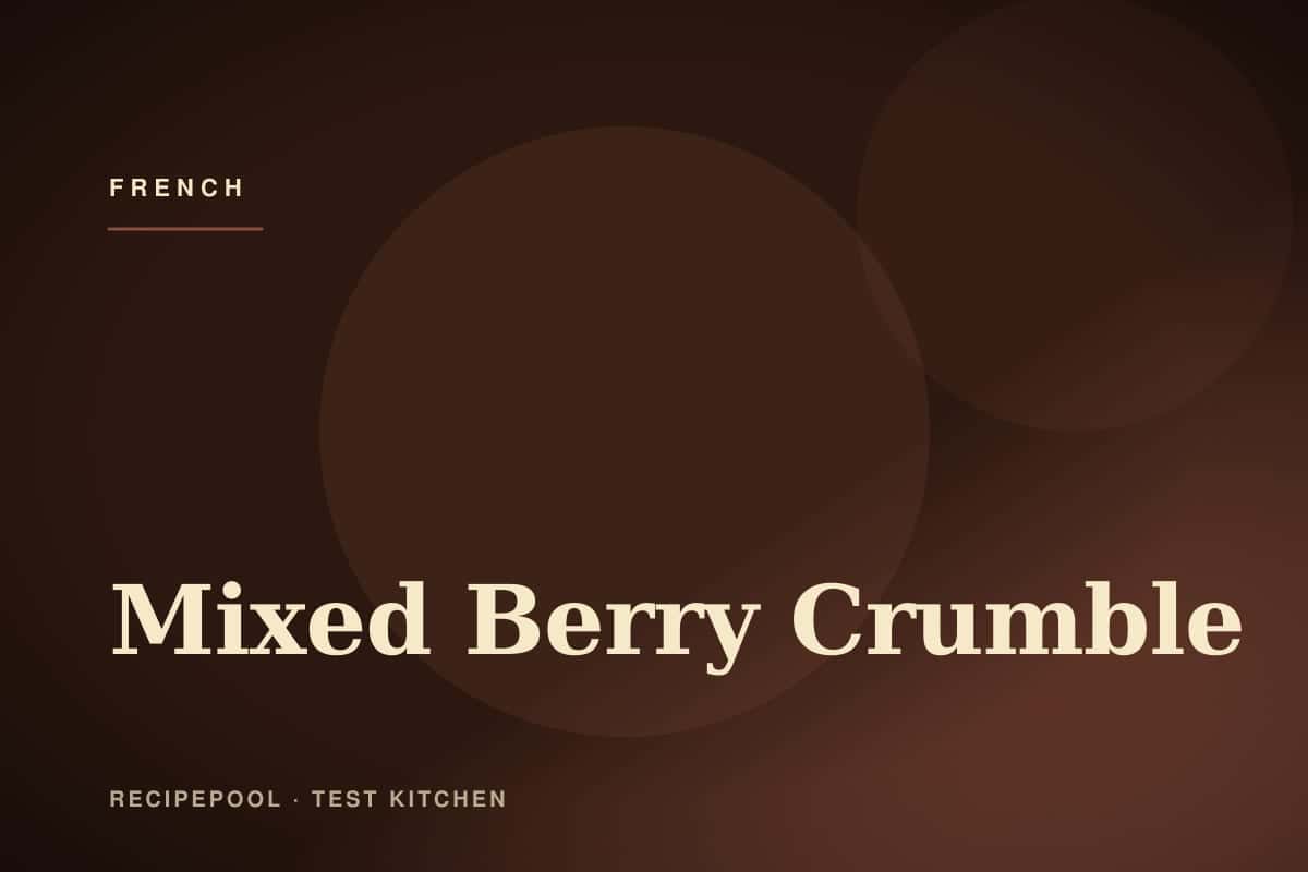 Mixed berry crumble in a baking dish with golden crumble topping and berries bubbling through