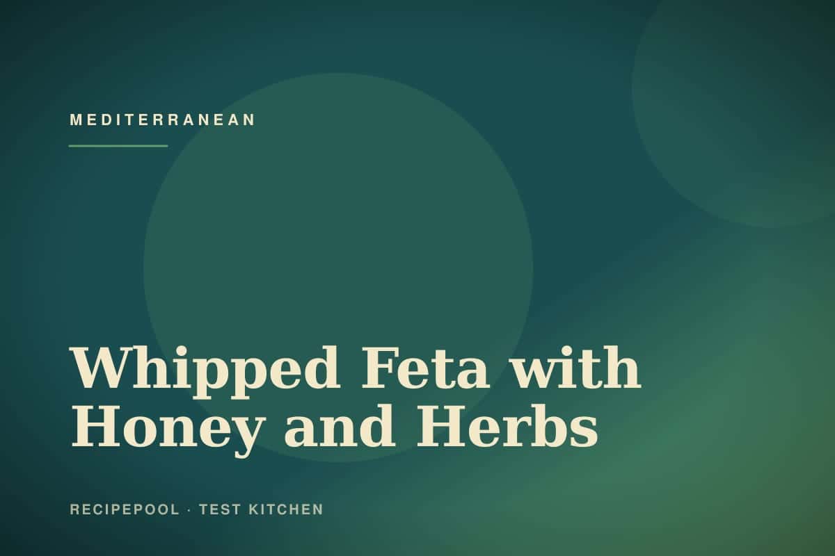 Bowl of whipped feta dip drizzled with honey and topped with fresh herbs