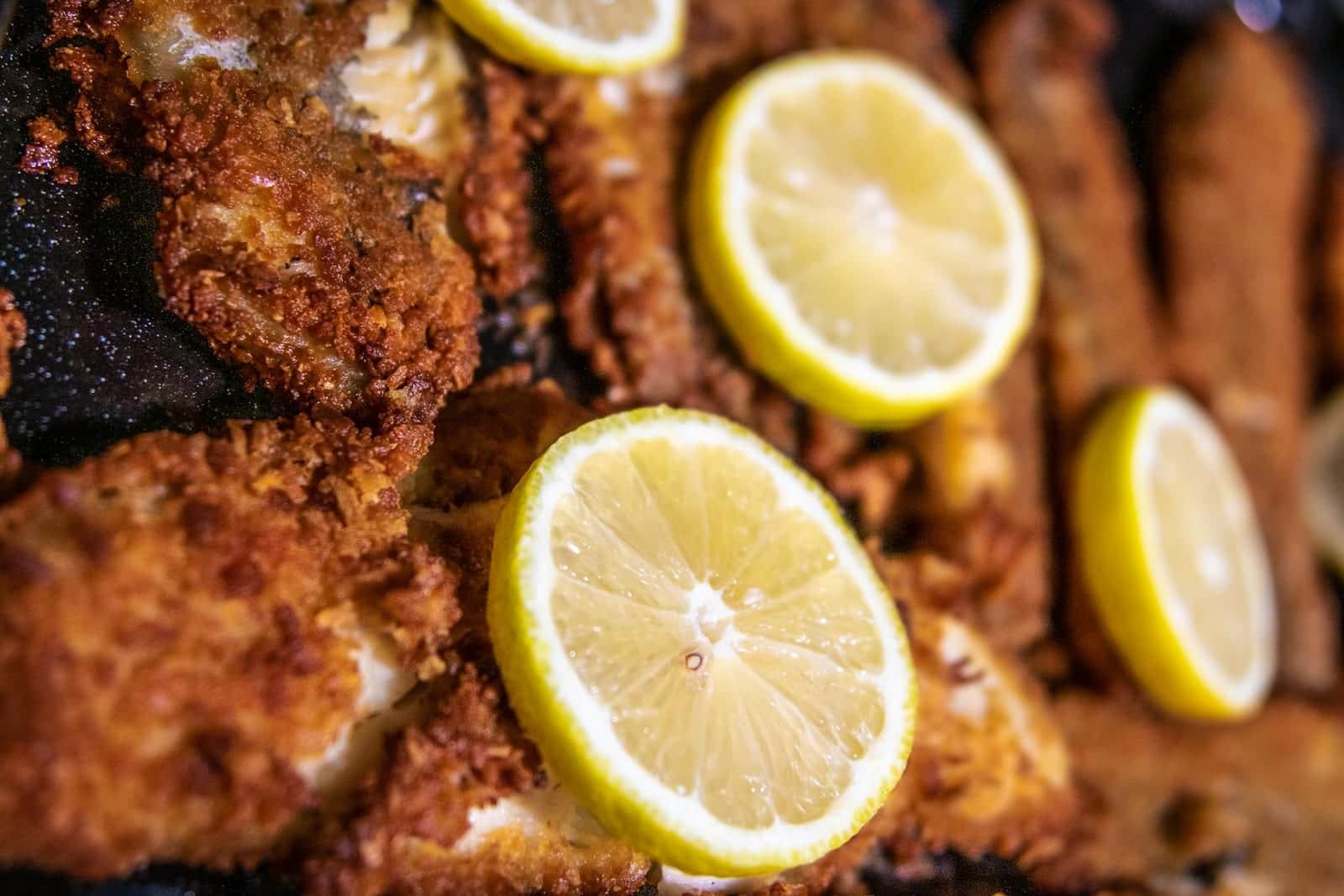 Baked lemon garlic tilapia-style fish fillets with crisp coating and lemon slices