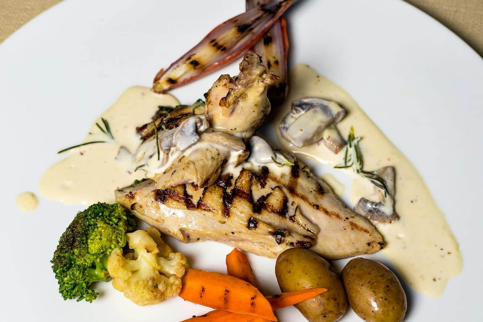 Chicken Marsala-style chicken breast with creamy mushroom sauce and vegetables