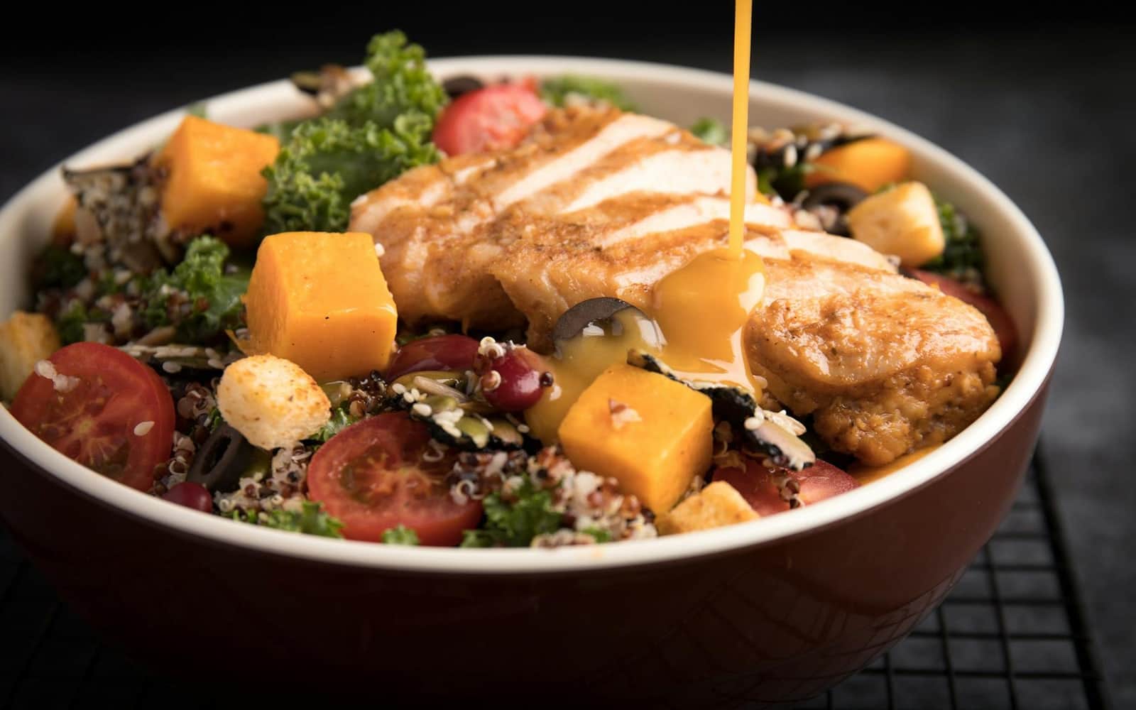 Chipotle chicken quinoa bowl with grilled chicken, grains, vegetables, and creamy dressing