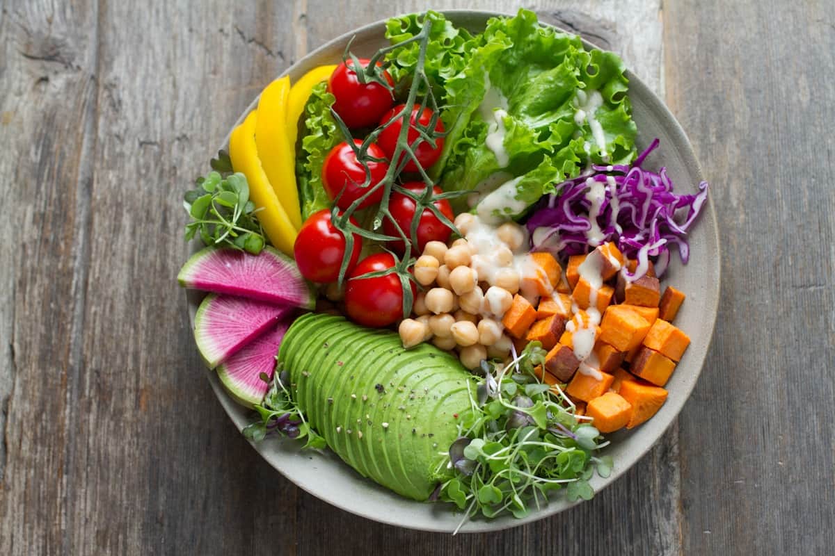 Colorful Mediterranean quinoa bowl with fresh vegetables, chickpeas, feta cheese, and herbs