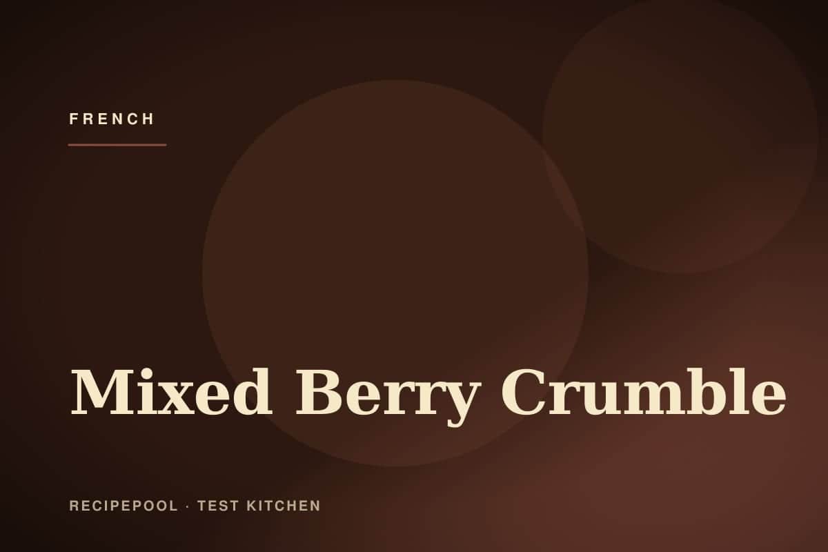 Mixed berry crumble in a baking dish with golden crumble topping and berries bubbling through
