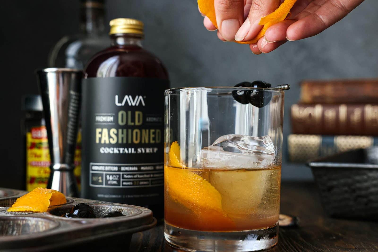 Old fashioned cocktail with orange peel and syrup on a polished bar setup