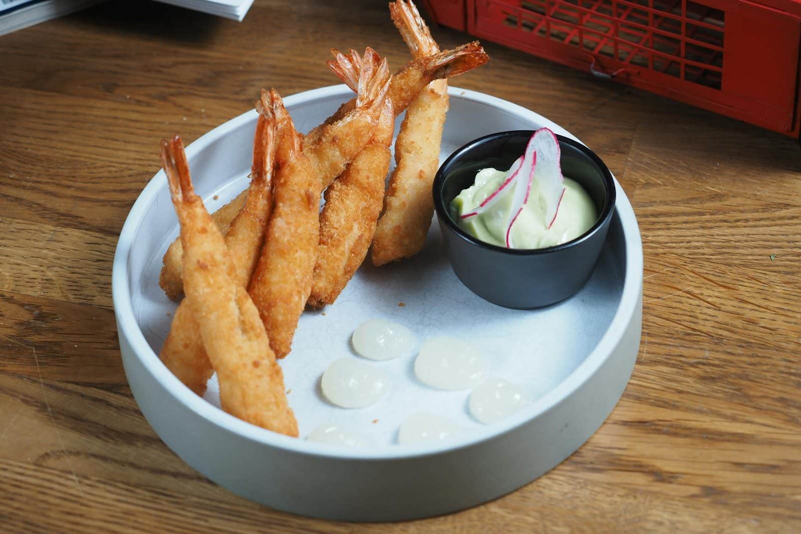 Shrimp tempura with crisp golden batter and creamy dipping sauce on a wooden table