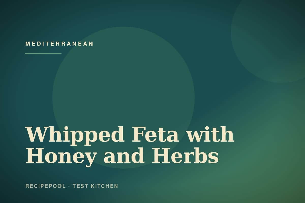 Bowl of whipped feta dip drizzled with honey and topped with fresh herbs