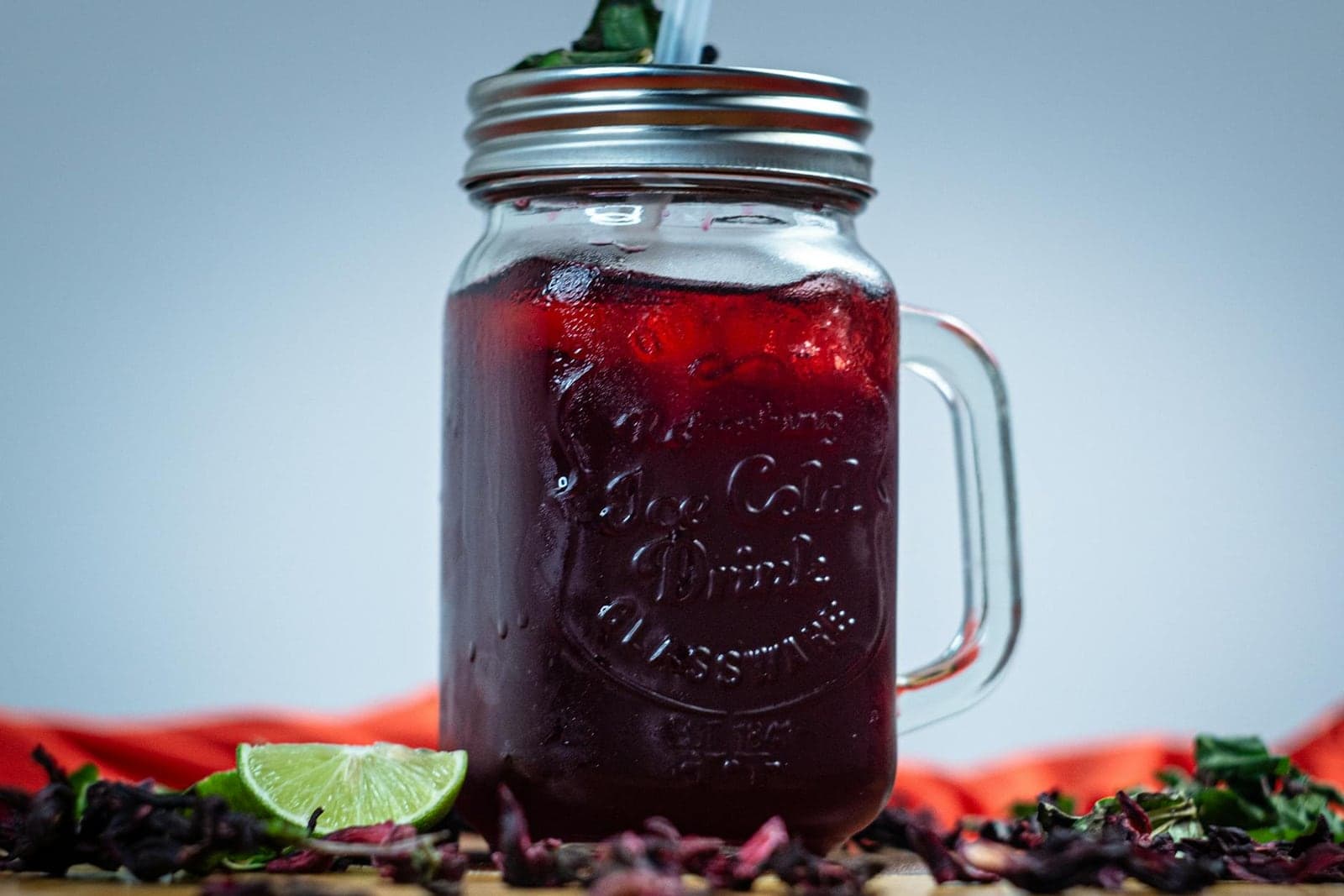 Agua fresca in a glass jar with hibiscus color, mint, and lime