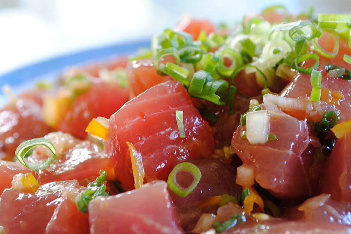 Ahi tuna poke cubes with scallions, sesame soy dressing, and diced aromatics