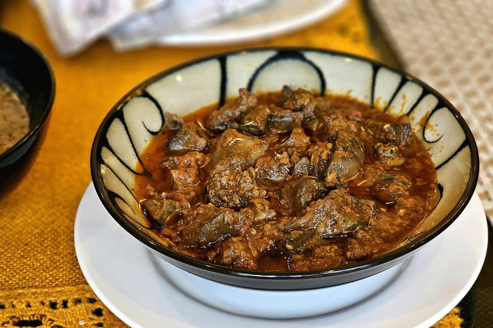 Aromatic lamb curry in a bowl with rich sauce and fresh herb garnish