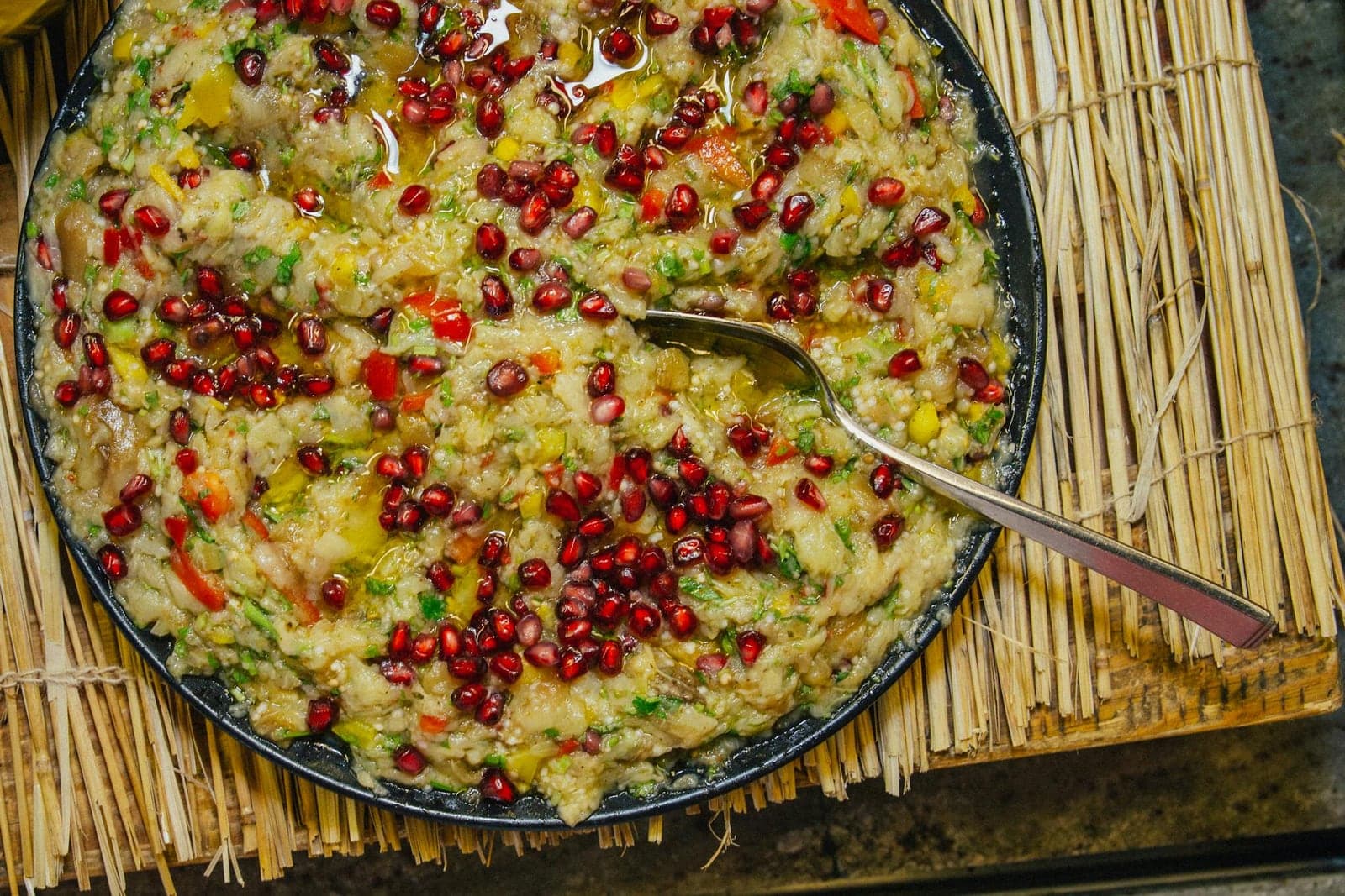 Baba ganoush eggplant dip garnished with pomegranate seeds and herbs