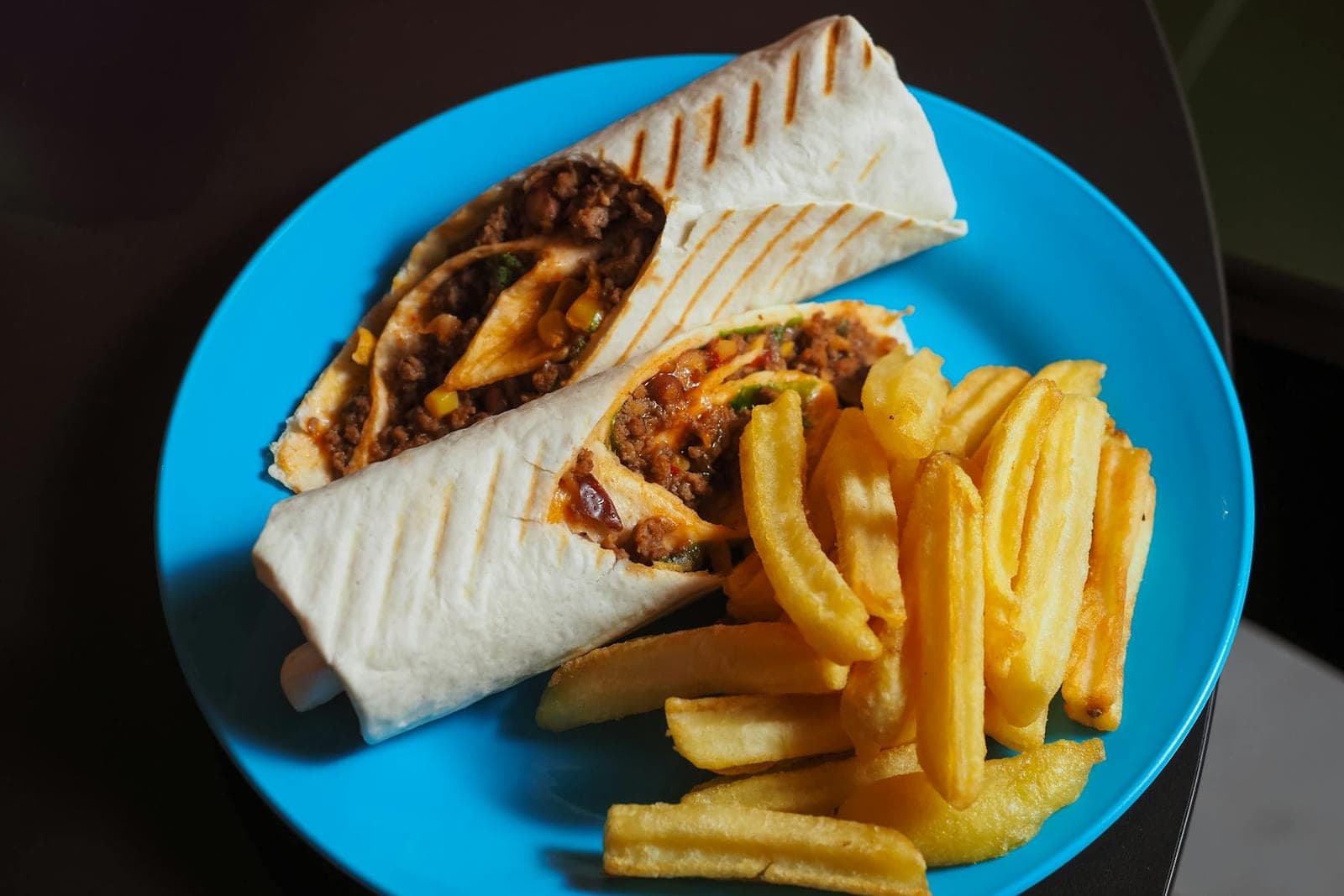 Beef and bean burrito wrap with a visible filling served on a blue plate