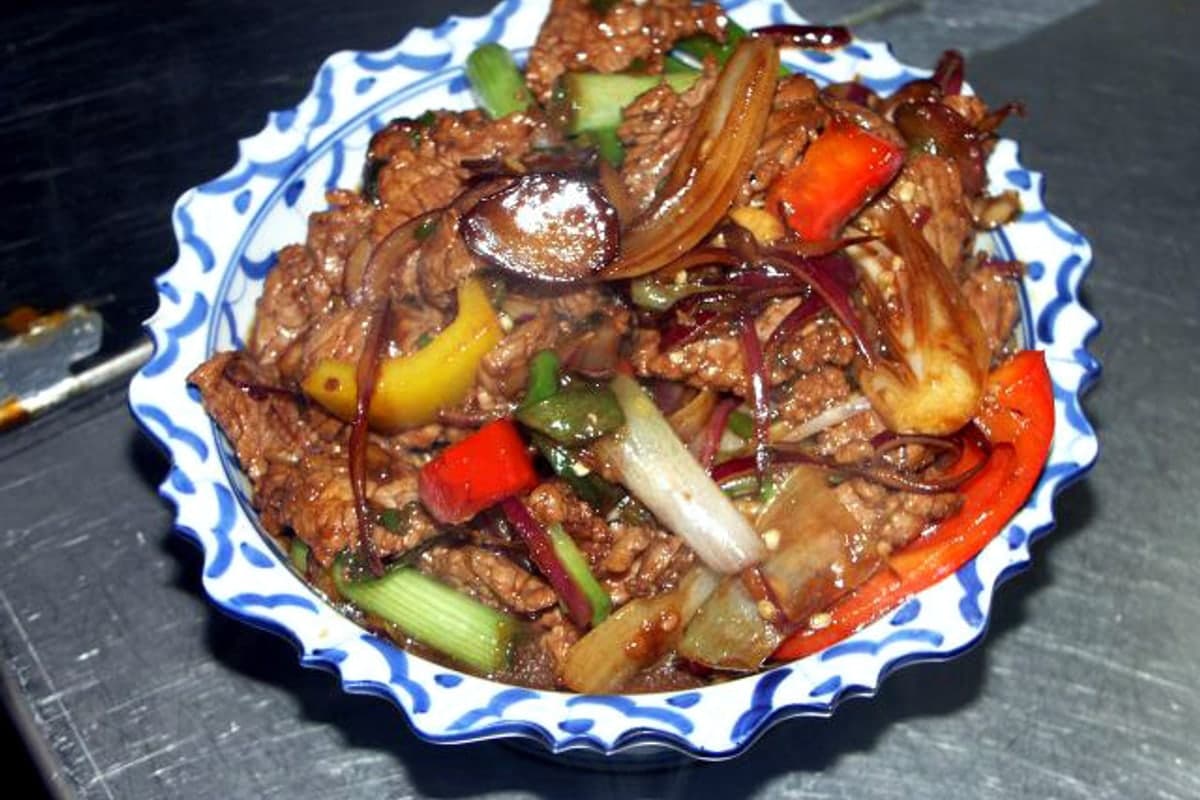 Beef and pepper stir fry with sliced beef, onions, and bell peppers in a glossy sauce