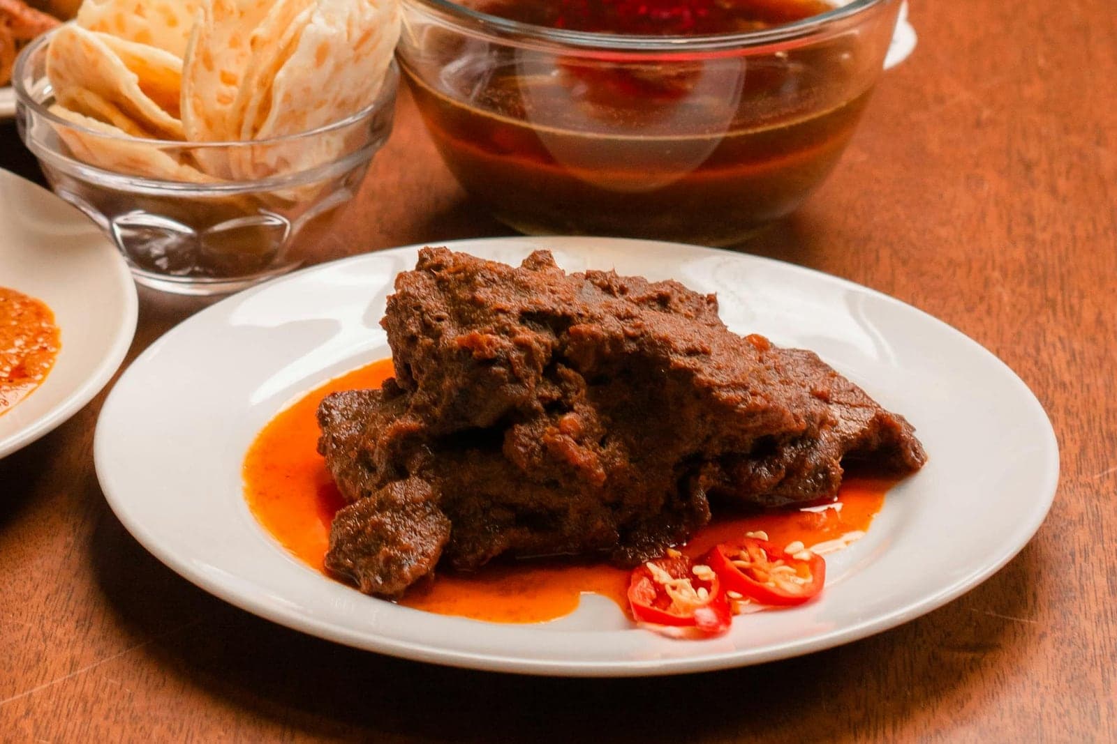 Beef rendang served with rich dark coconut curry sauce and red chilies