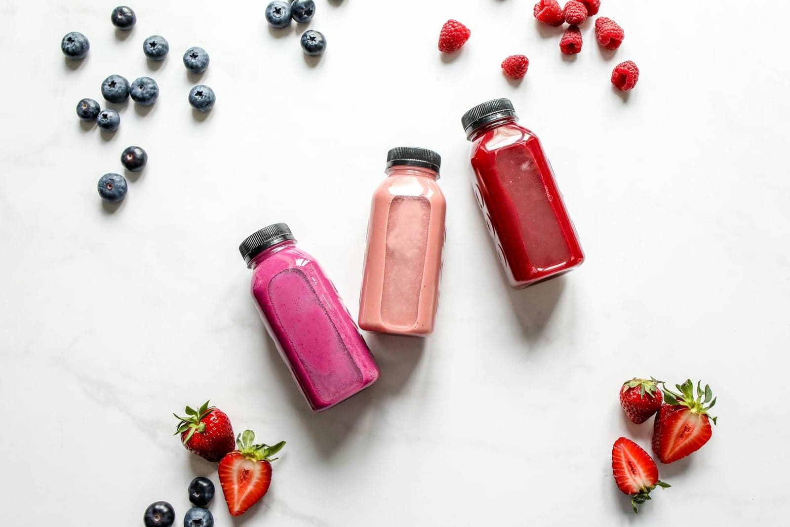 Berry blast smoothies in small bottles with strawberries, blueberries, and raspberries