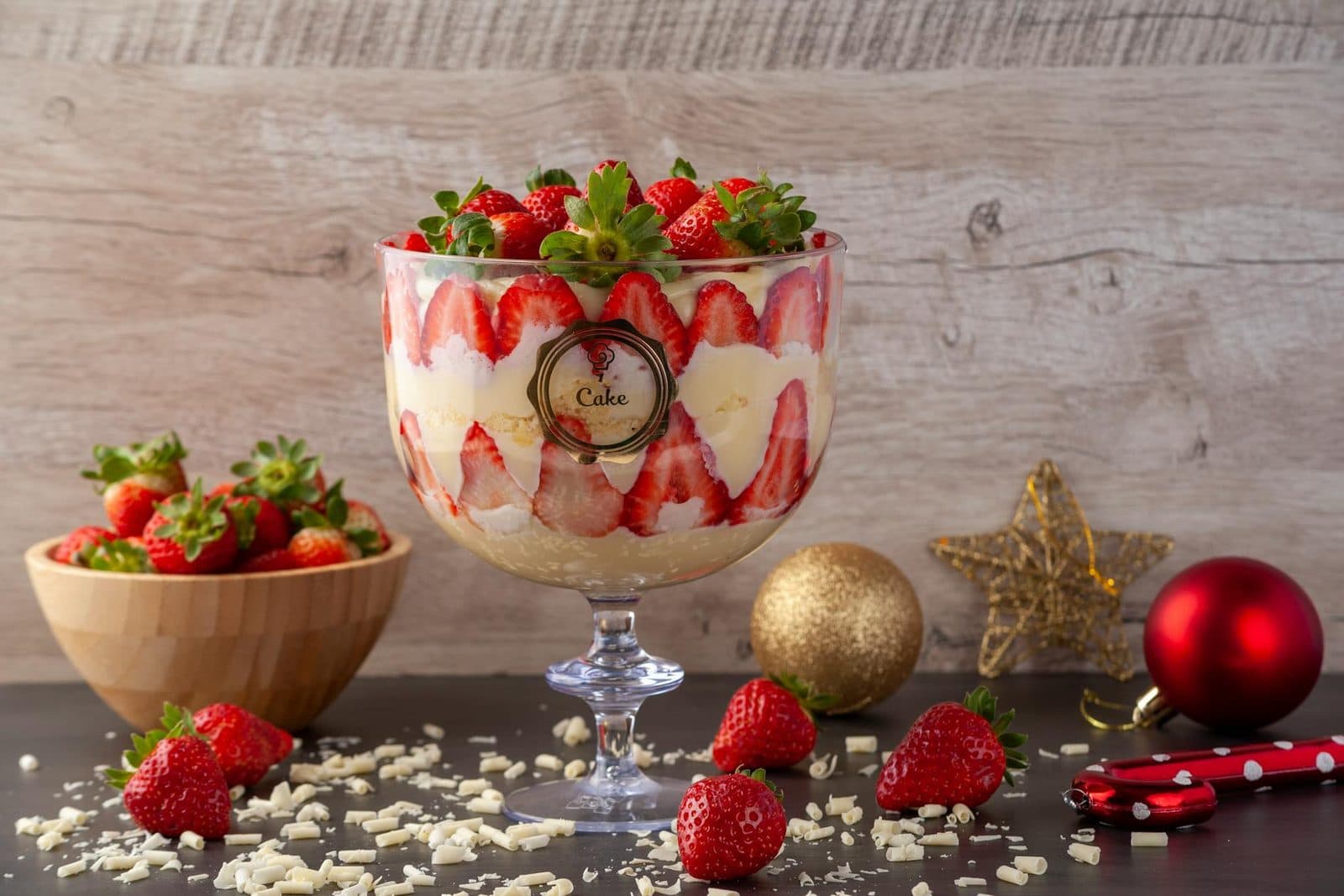 Berry trifle layered with cream and strawberries in a glass bowl