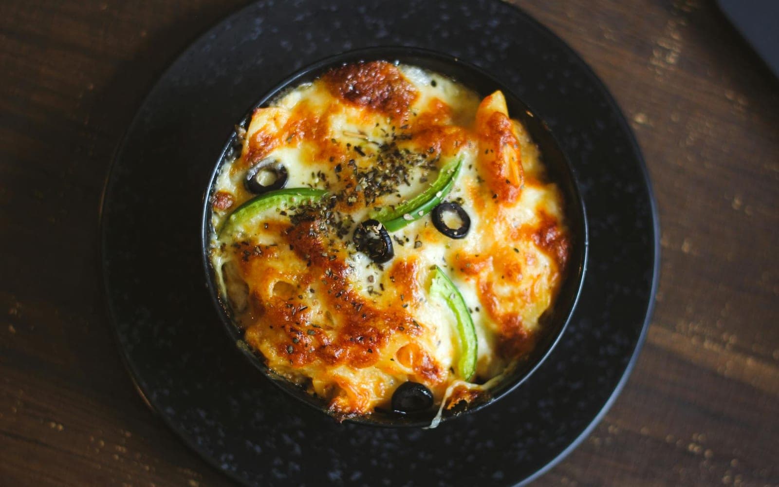 Buttery egg noodle bake with cheesy baked noodles in a dark serving bowl