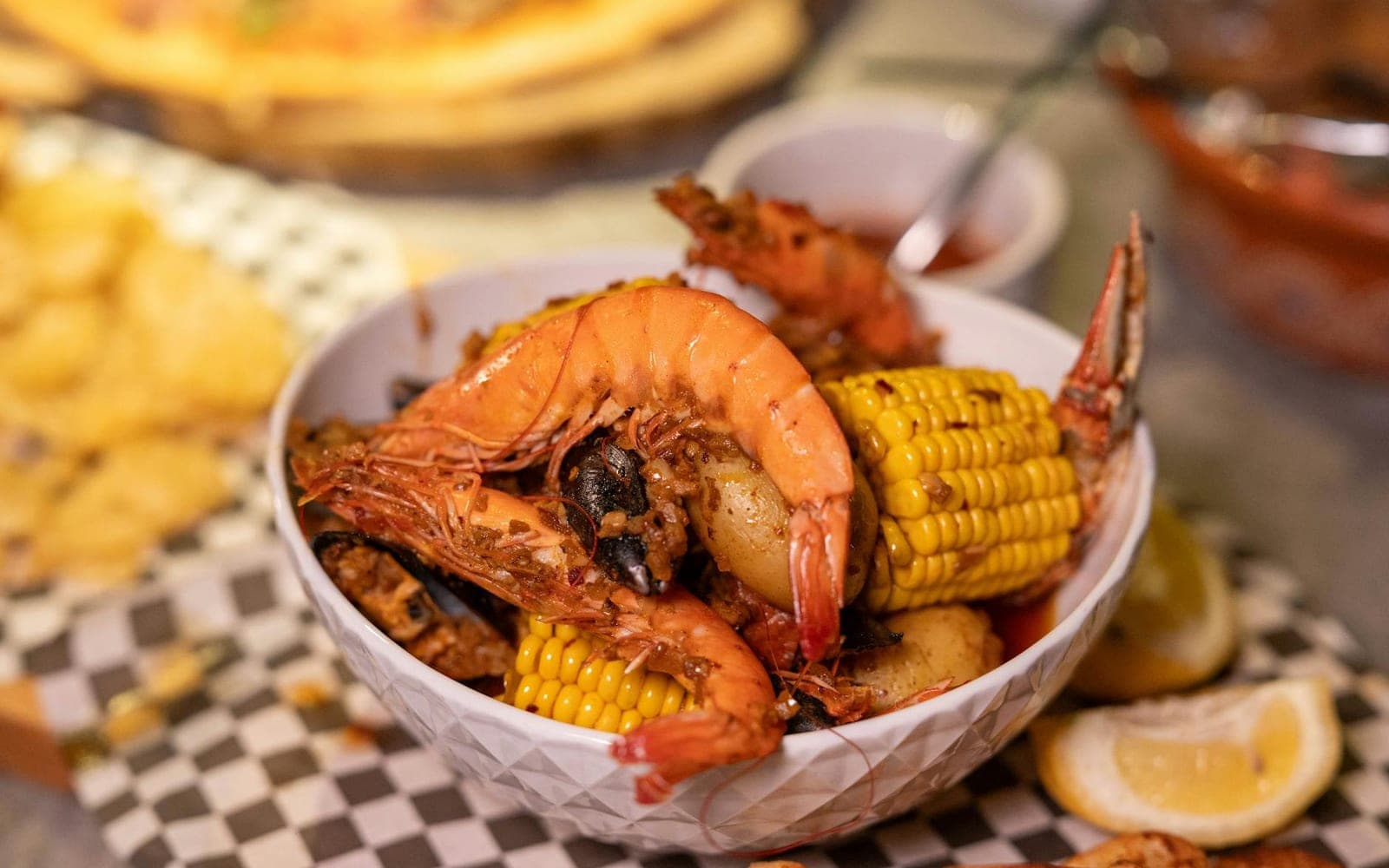 Cajun shrimp boil with shrimp, corn, potatoes, lemon, and seasoning in a bowl