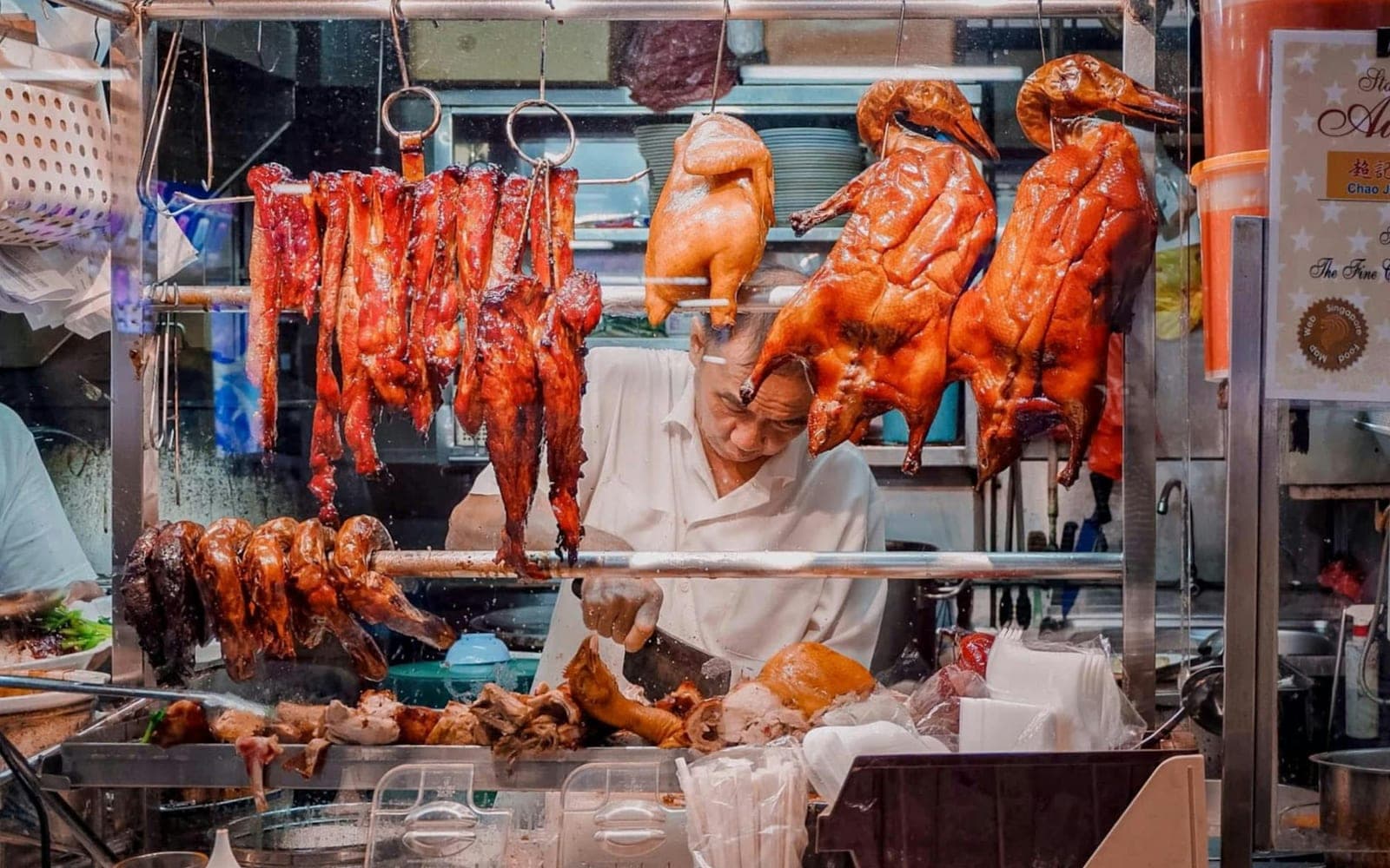 Char siu pork and roasted red pork hanging at a market stall