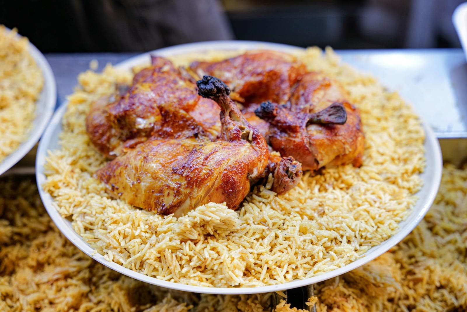 Chicken biryani with spiced rice and browned chicken served on a large platter