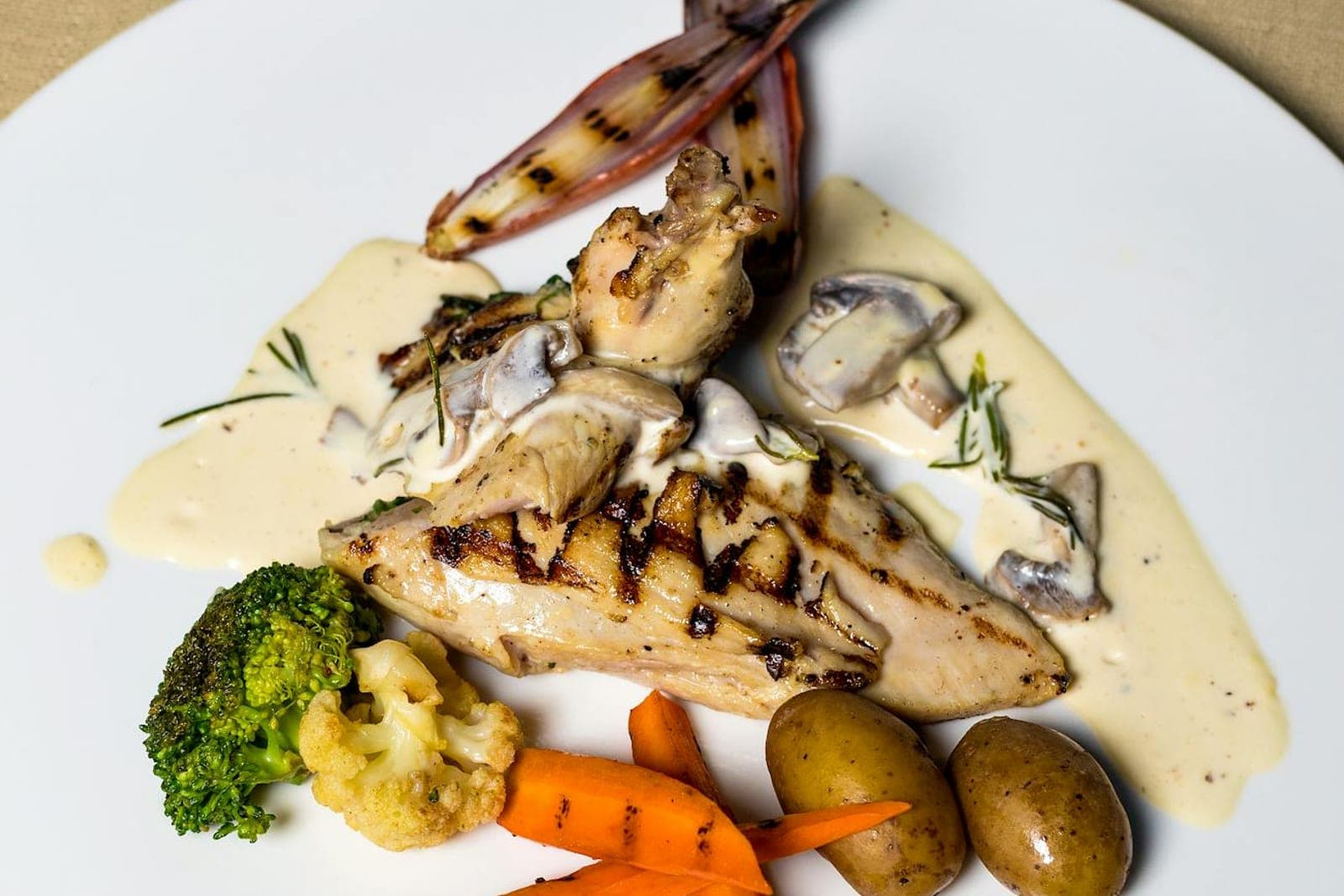 Chicken Marsala-style chicken breast with creamy mushroom sauce and vegetables
