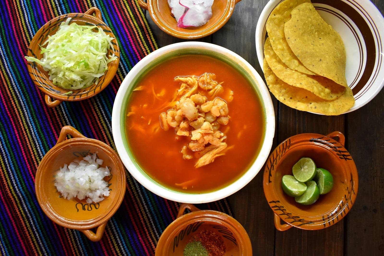 Chicken tortilla soup with tomato broth, tortilla chips, lime, and fresh toppings