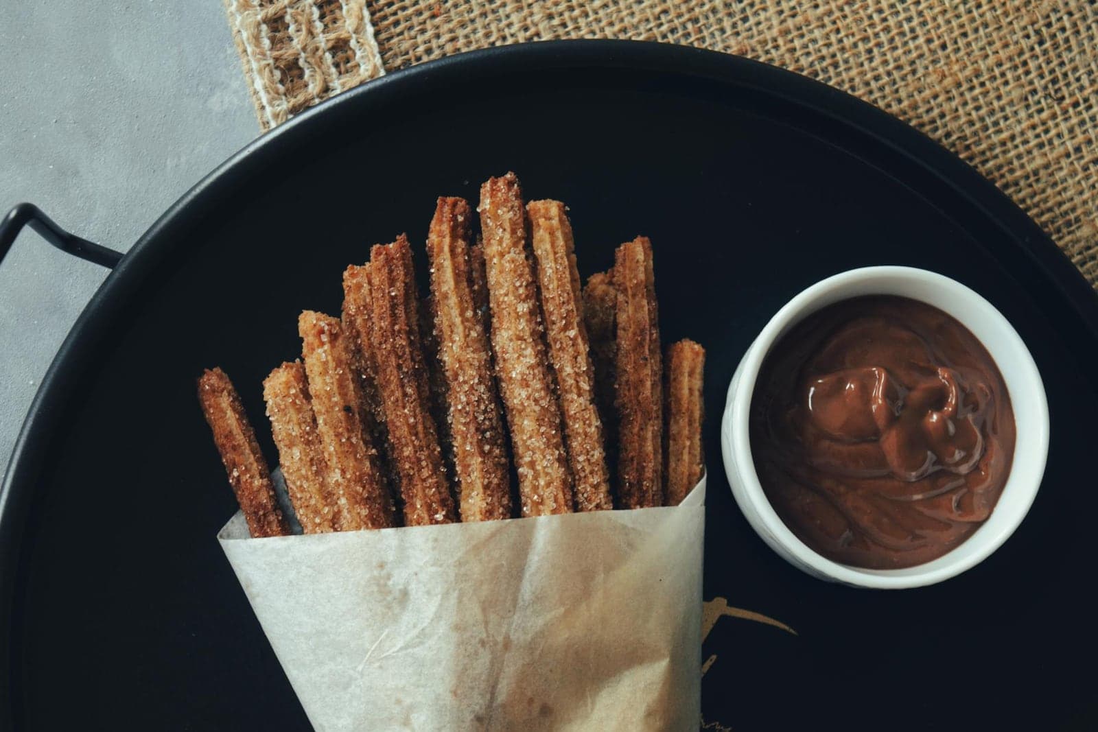 Spanish churros served with a cup of thick chocolate dipping sauce