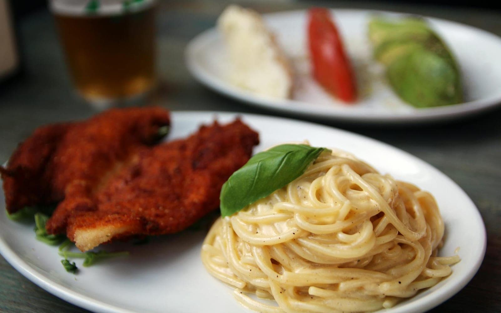 Creamy chicken spaghetti with pasta, chicken, basil, and creamy sauce on a white plate