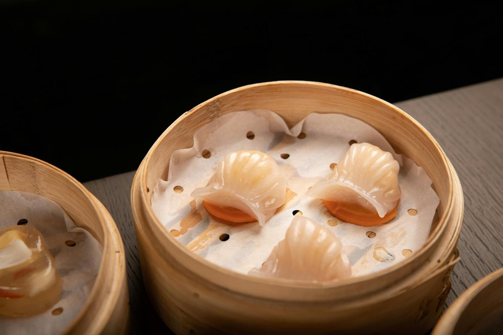 Har gow shrimp dumplings in bamboo steamer baskets at a dim sum table