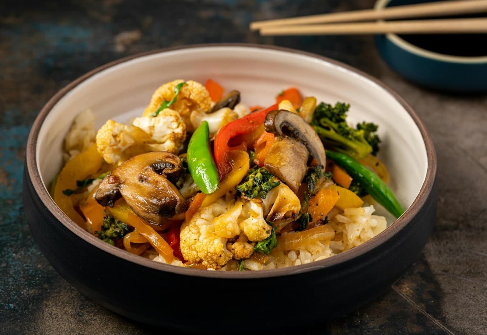 Edamame vegetable stir-fry bowl with broccoli, mushrooms, peppers, and rice