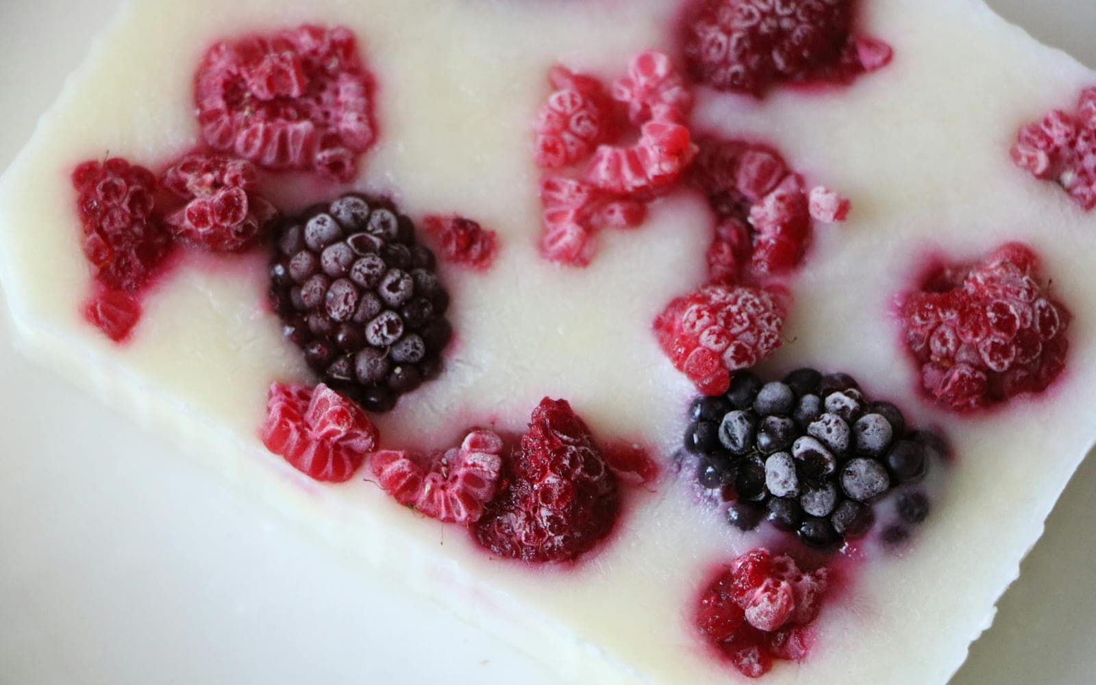 Frozen yogurt bites with berries set into a creamy yogurt bar