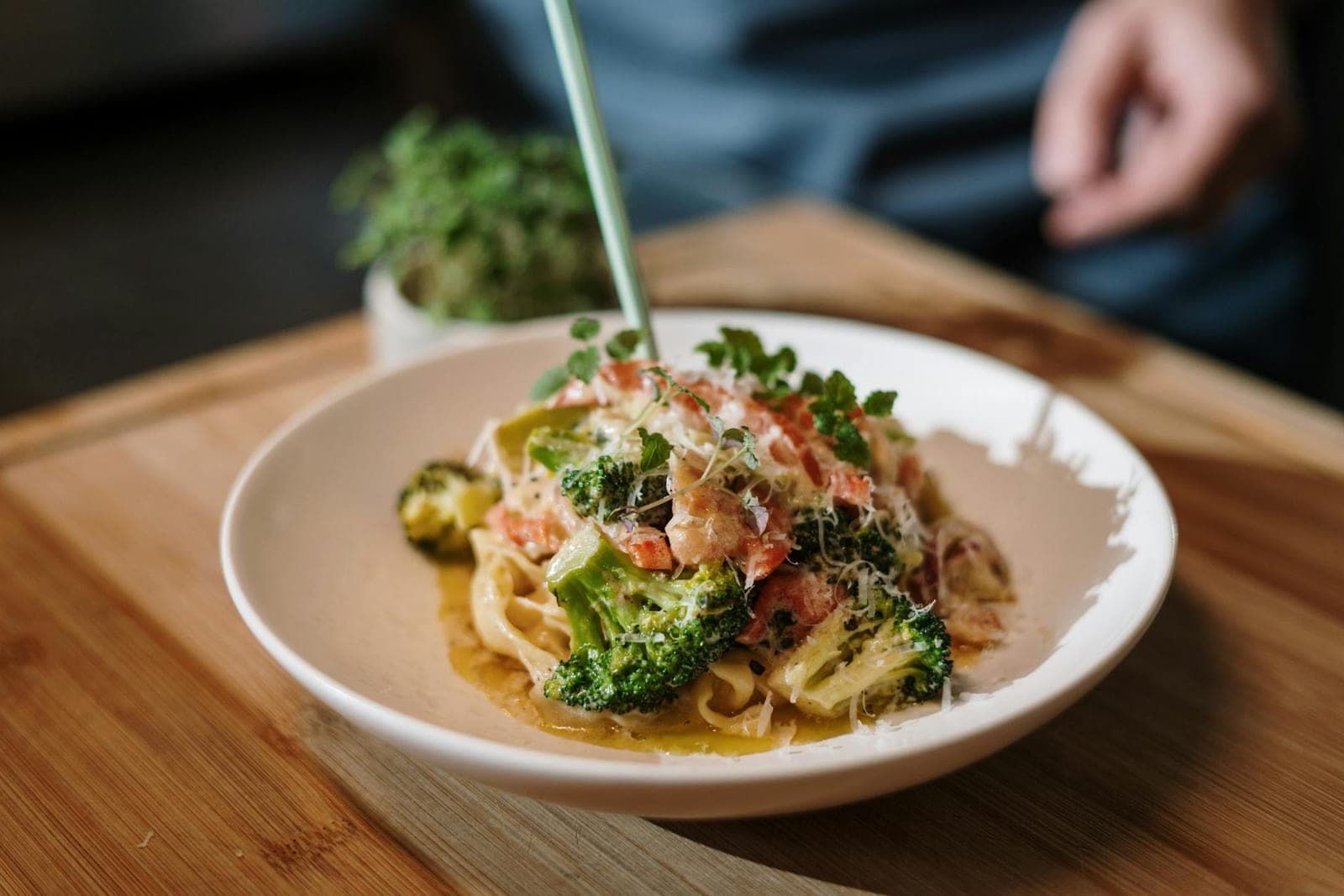 Italian sausage and broccoli rabe pasta with tomatoes and grated cheese on a white plate