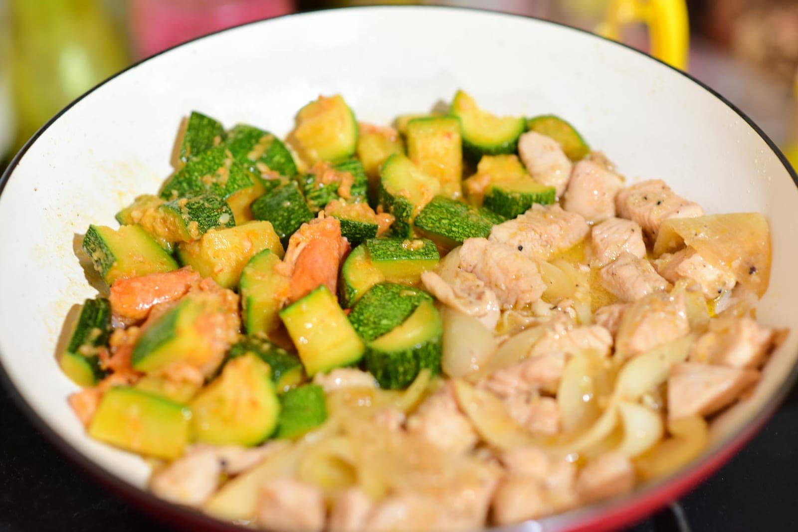 Mediterranean chicken sheet pan dinner with chicken, zucchini, and vegetables in a skillet