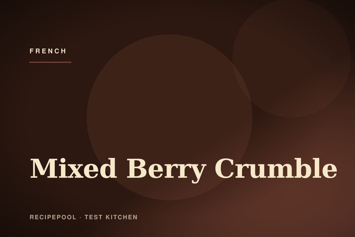 Mixed berry crumble in a baking dish with golden crumble topping and berries bubbling through