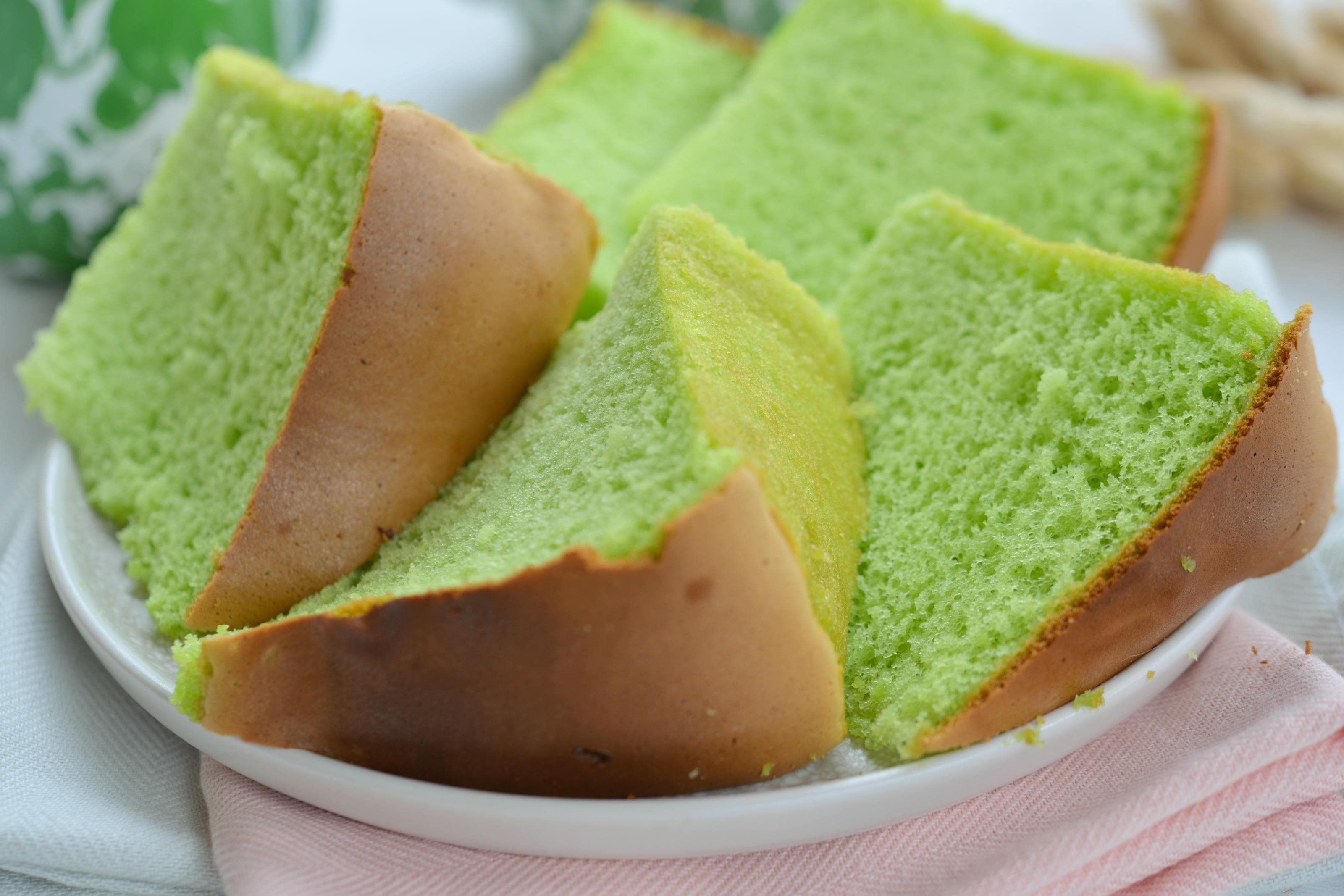Pandan chiffon cake slices with a light green crumb served on a white plate