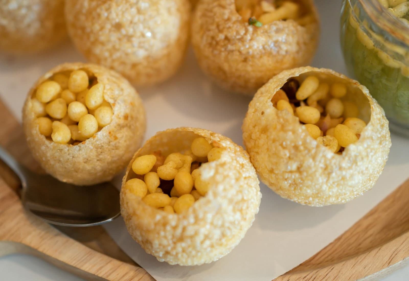 Pani puri Indian street food shells filled with chickpeas and served with spiced water