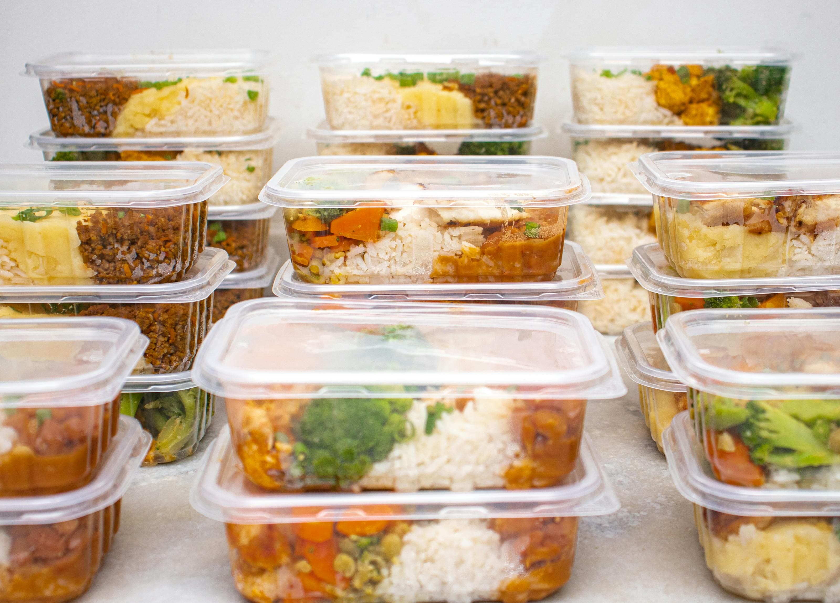 Rice and beans meal prep containers with vegetables, beans, and herbs