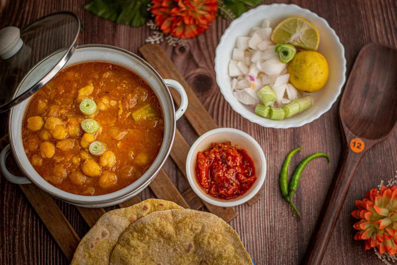 Roti canai flaky flatbread served with chickpea curry, onions, chilies, and chutney