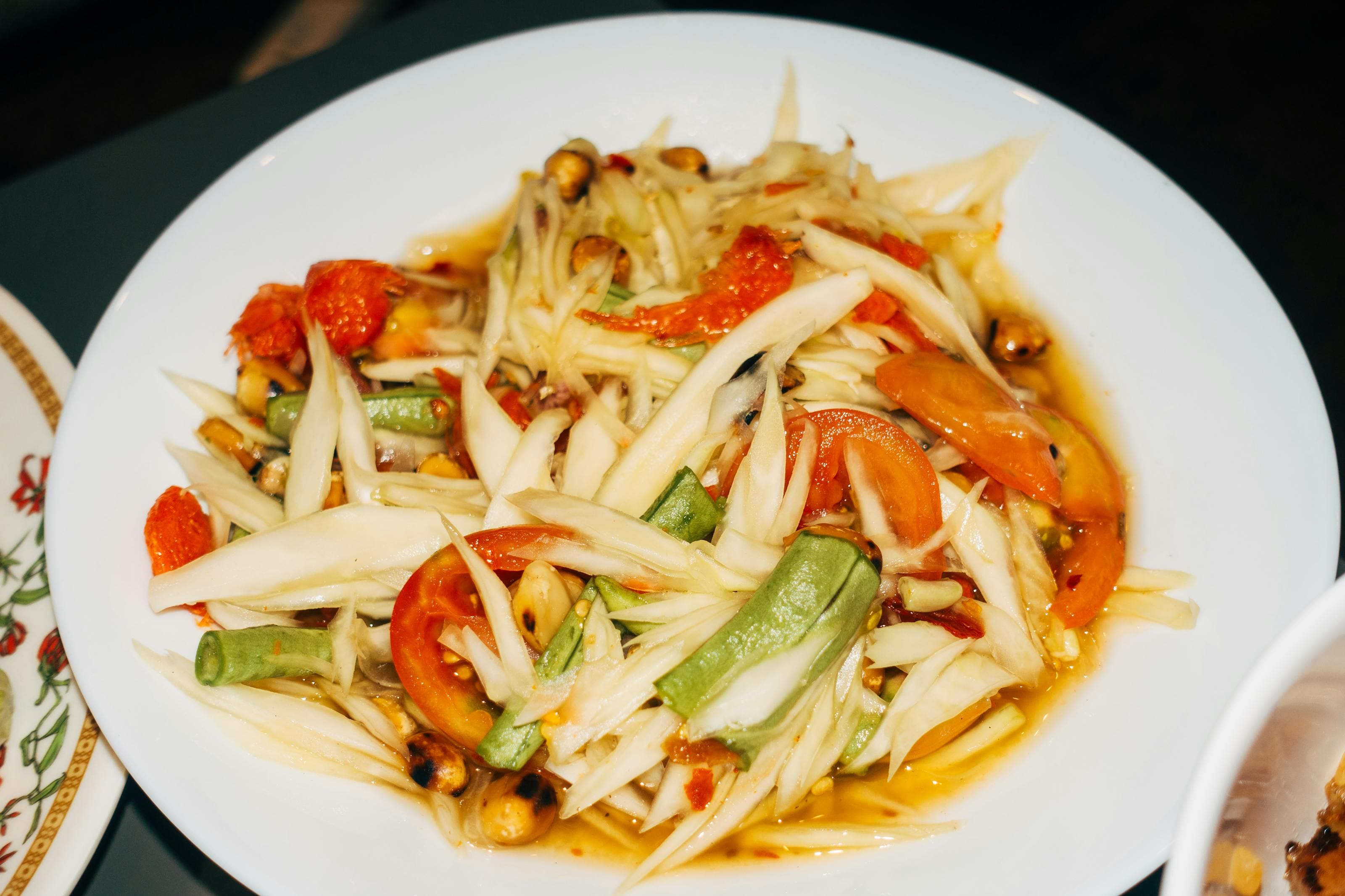 Som tum green papaya salad with tomato, long beans, chilies, and lime dressing