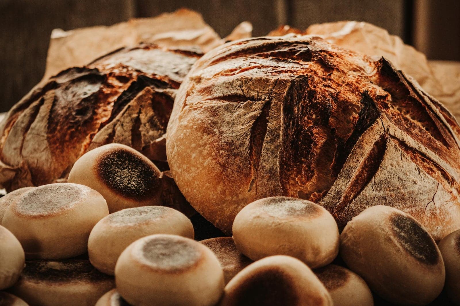 Rustic sourdough bread loaves with browned crust on a bakery table