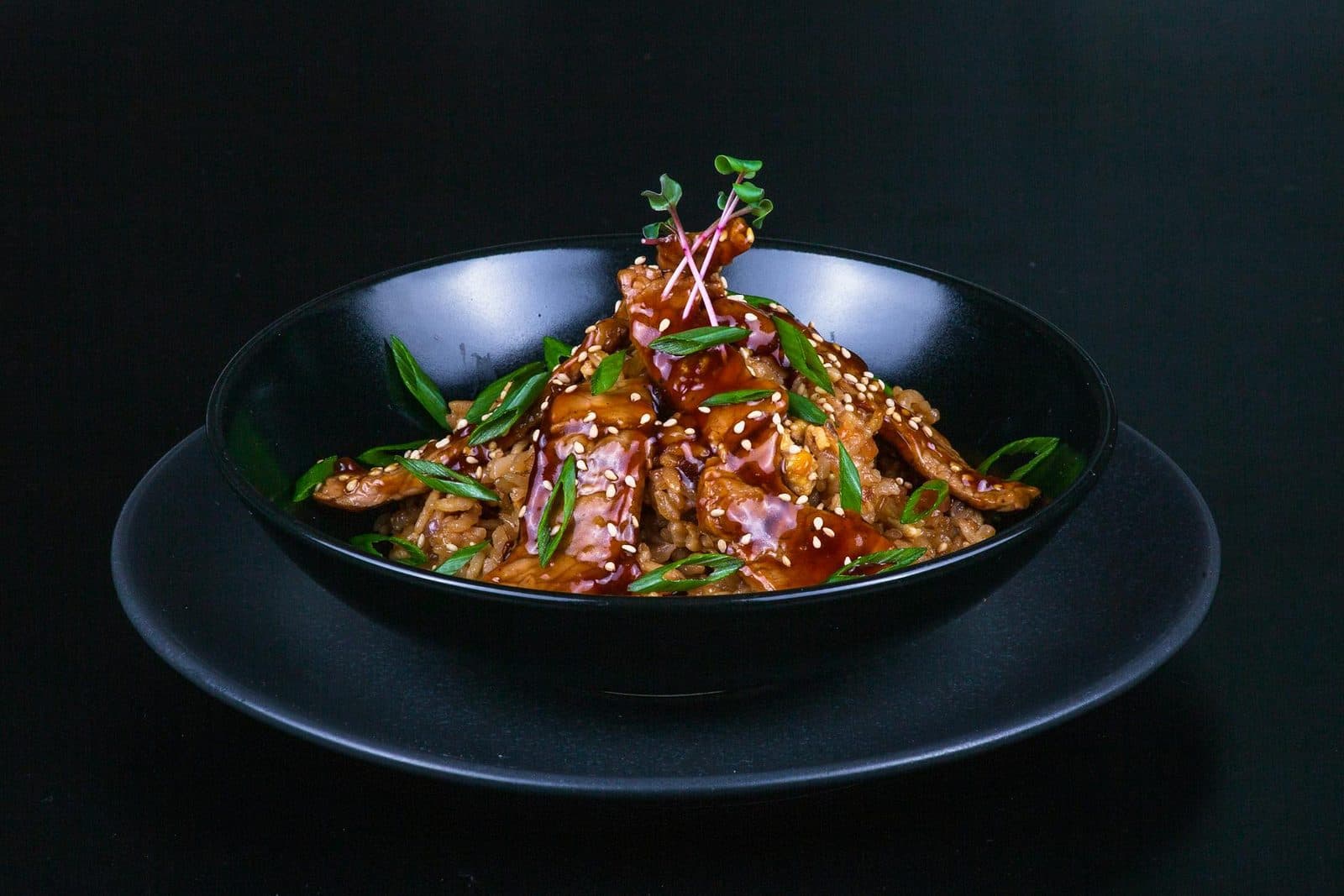Family teriyaki chicken served with rice, sesame seeds, and sliced scallions