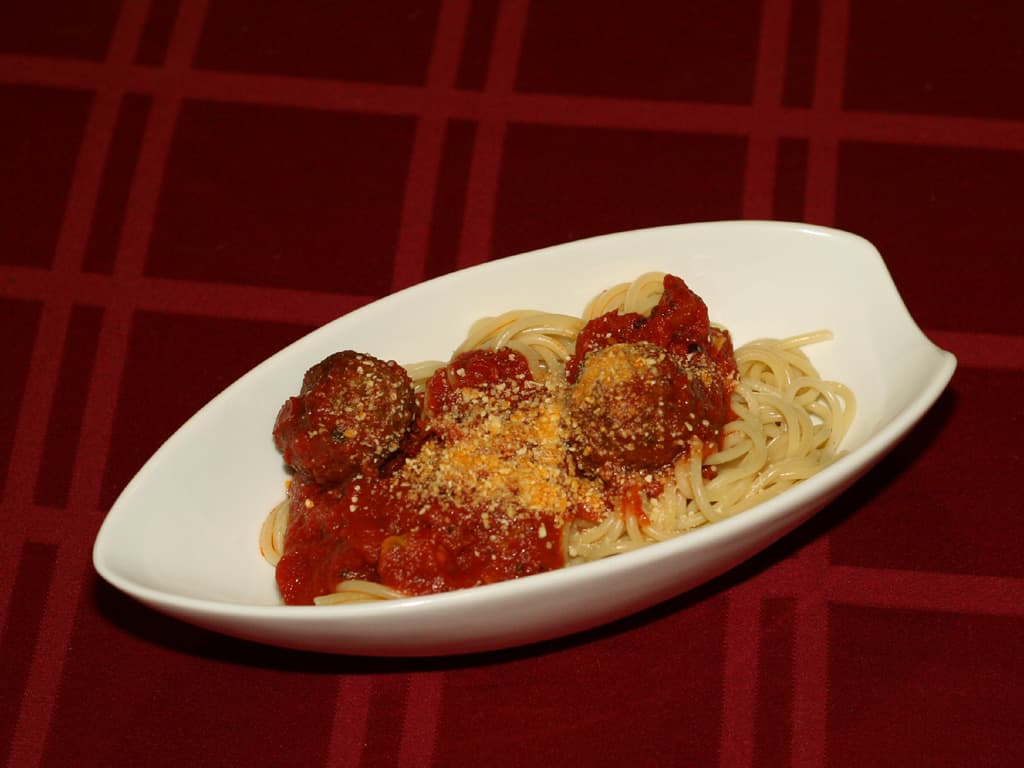 Plate of spaghetti and meatballs with marinara sauce and Parmesan