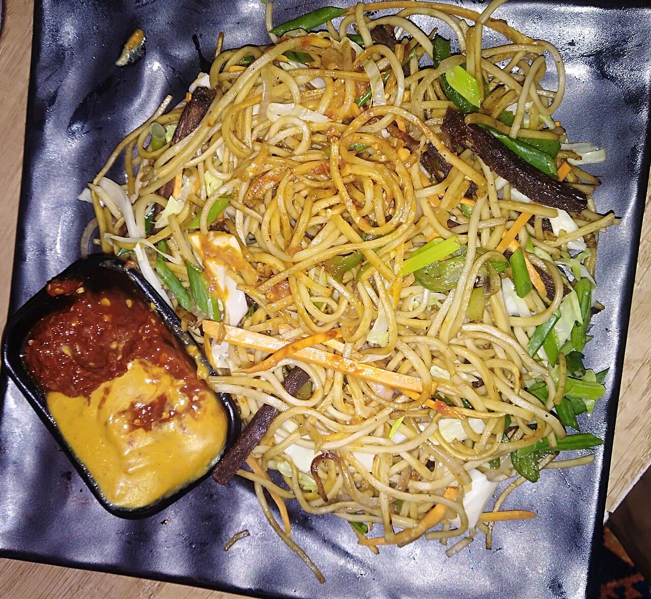 Plate of Chinese chow mein with pan-fried egg noodles, cabbage, and bean sprouts