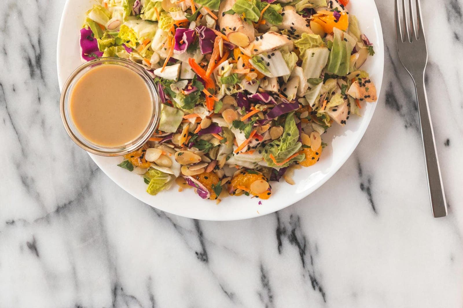 Asian chicken salad bowl with shredded vegetables, herbs, and creamy dressing