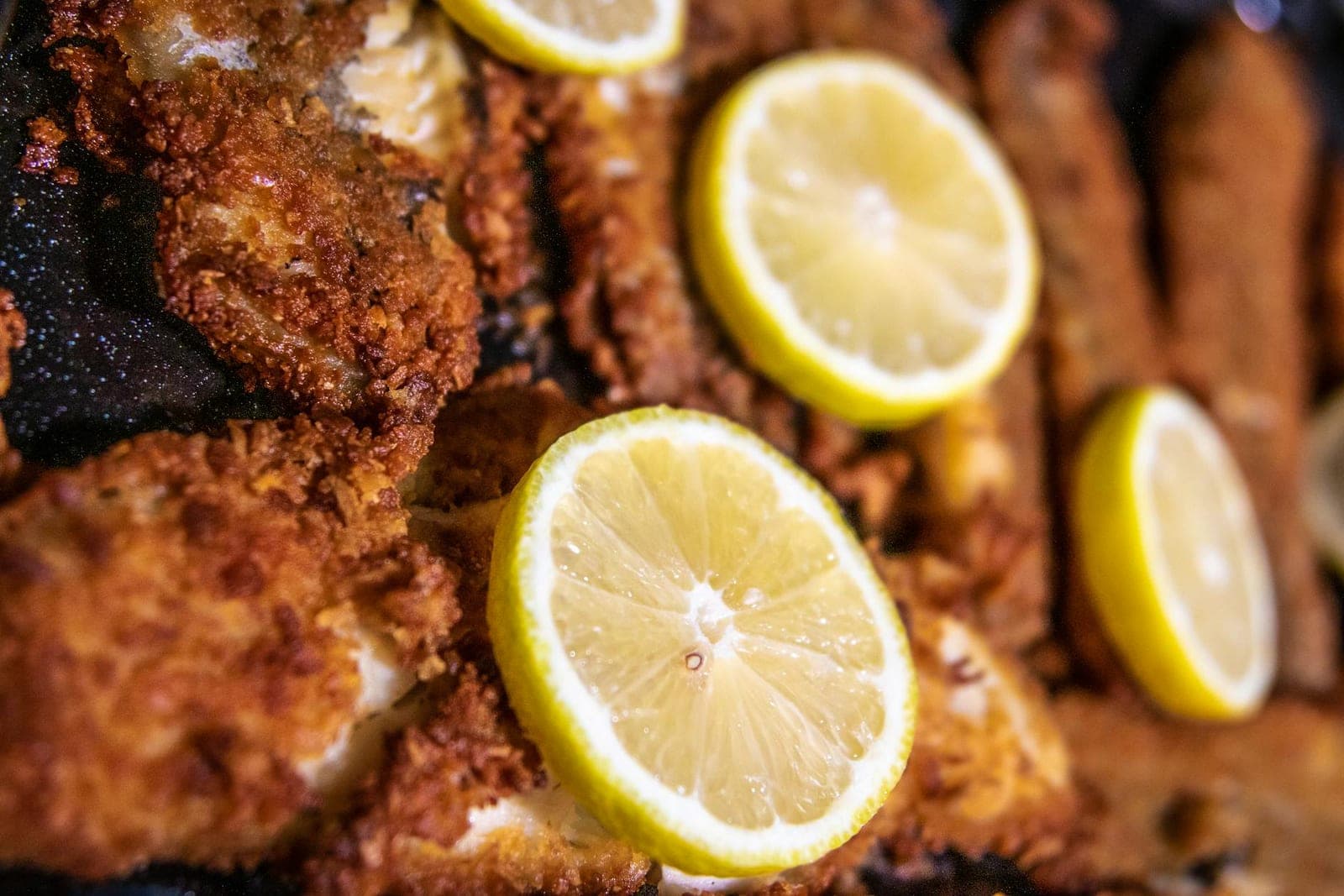Baked lemon garlic tilapia-style fish fillets with crisp coating and lemon slices