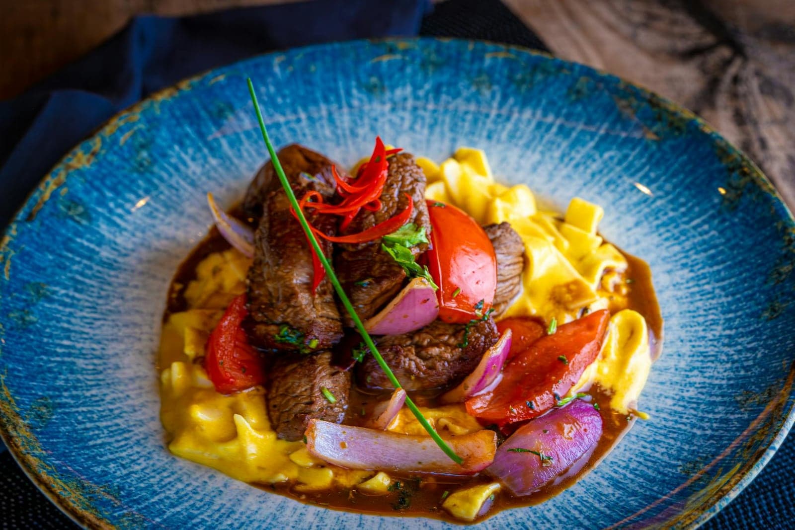 Beef stroganoff with tender beef, creamy sauce, pasta, and vegetables in a blue bowl