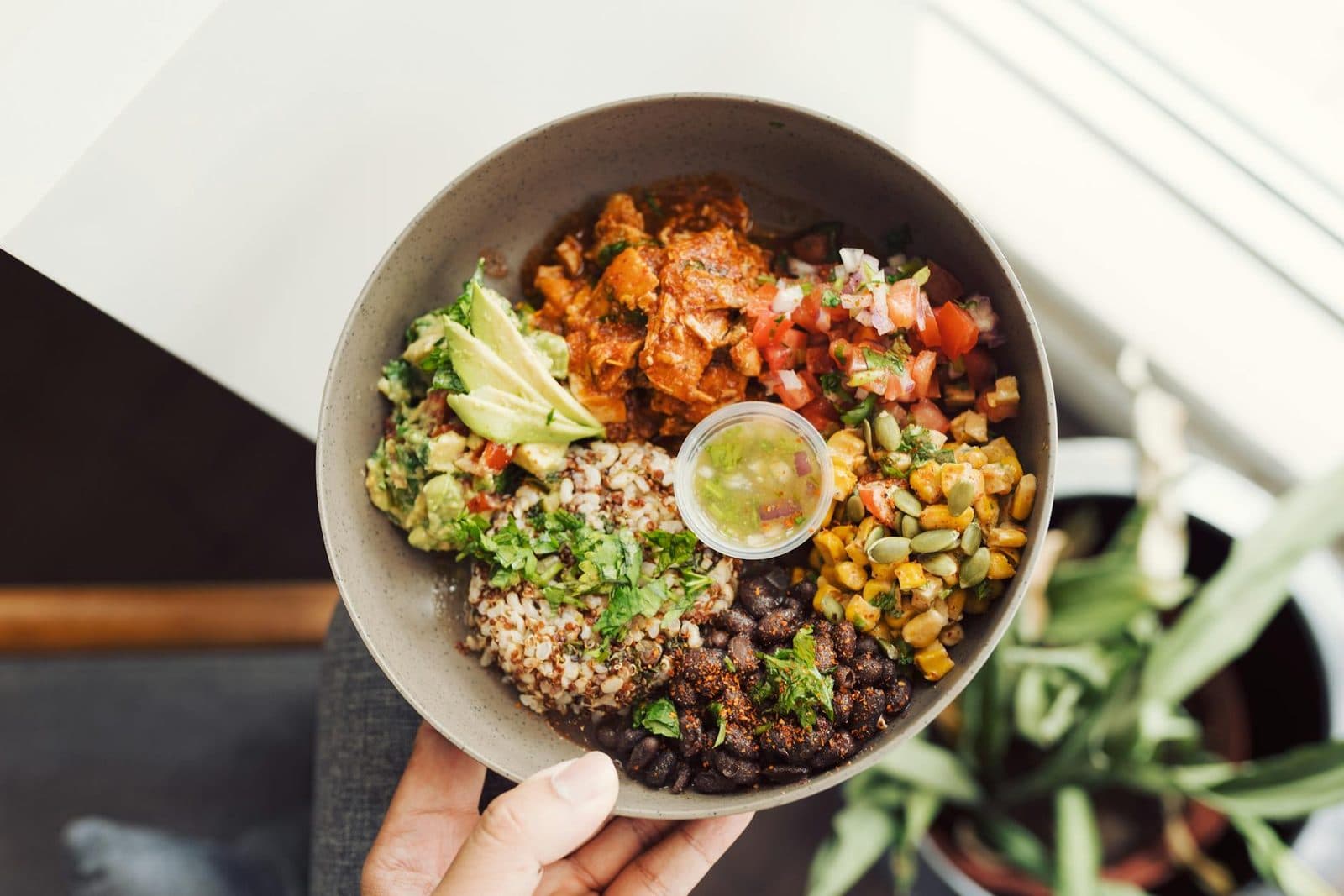 Black bean quinoa bowls with avocado, corn, salsa, lime, and fresh herbs