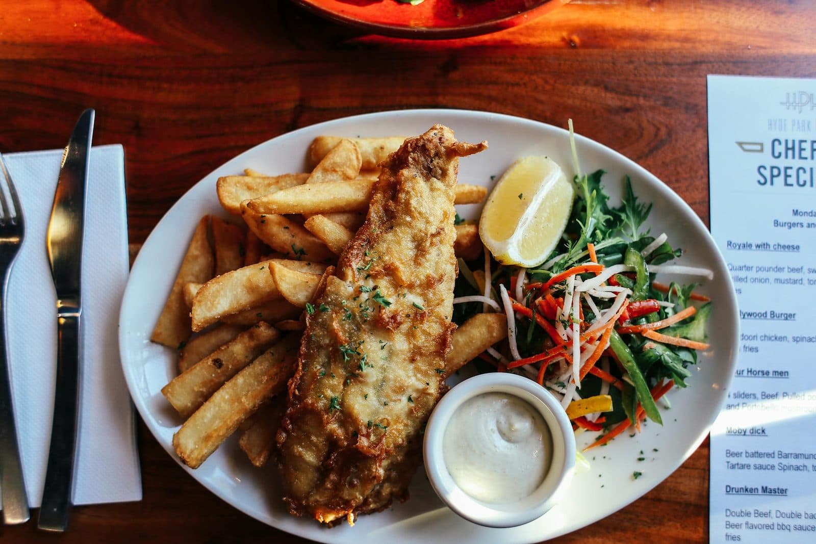 British fish and chips with crisp battered fish, thick chips, tartar sauce, and salad