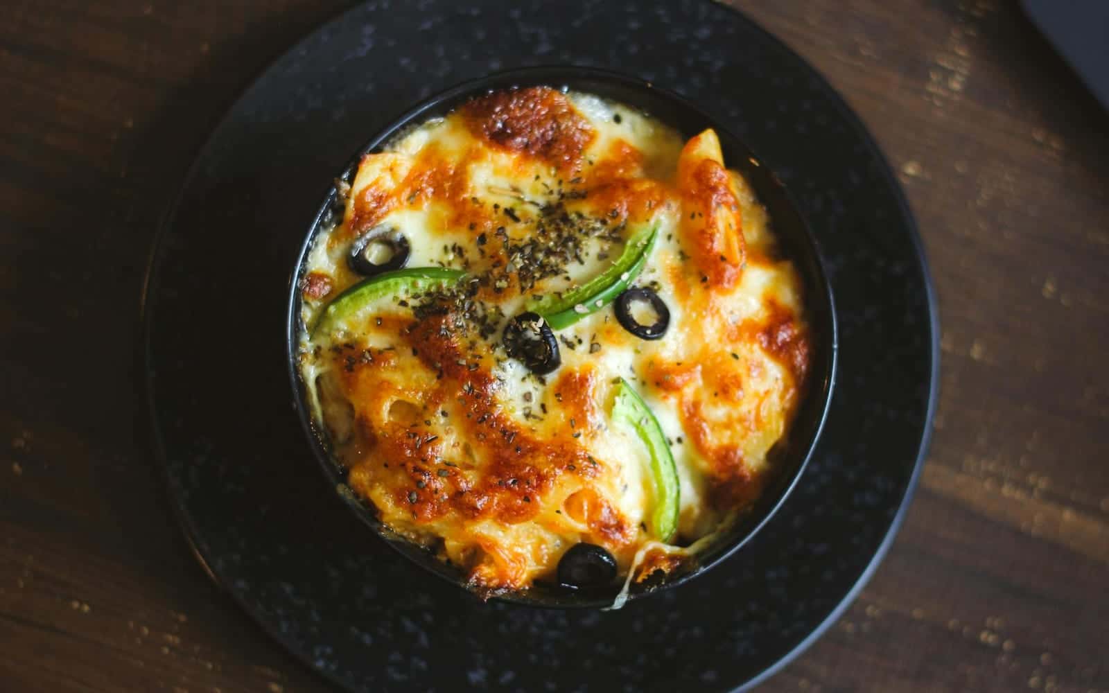 Buttery egg noodle bake with cheesy baked noodles in a dark serving bowl